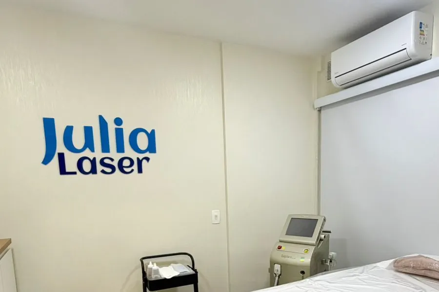Logo Julia Laser em letras azuis na parede da sala de atendimento